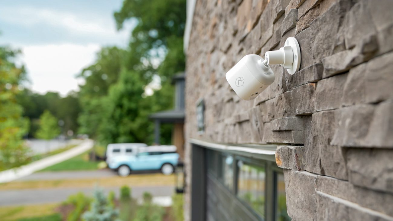 The outside of a house with a security camera pointing the the driveway